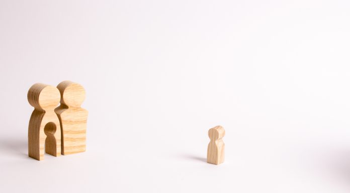 wooden figures of a man and a woman, and the woman has a child shaped hole in the middle of her. The child shaped wooden piece is off to the side, symbolic of infertility