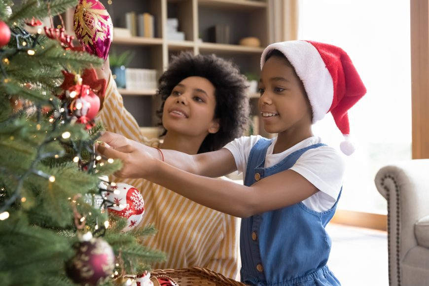 a single mom and her daughter decorating the Christmas tree