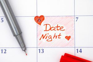 Reminder date night on calendar with red pen and hearts