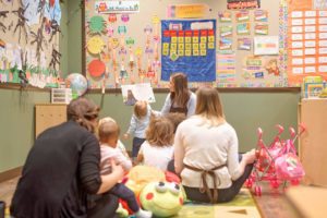 preschool teacher reading to kids in a classroom
