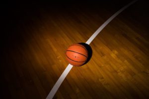 basketball lit up on a dark gym floor