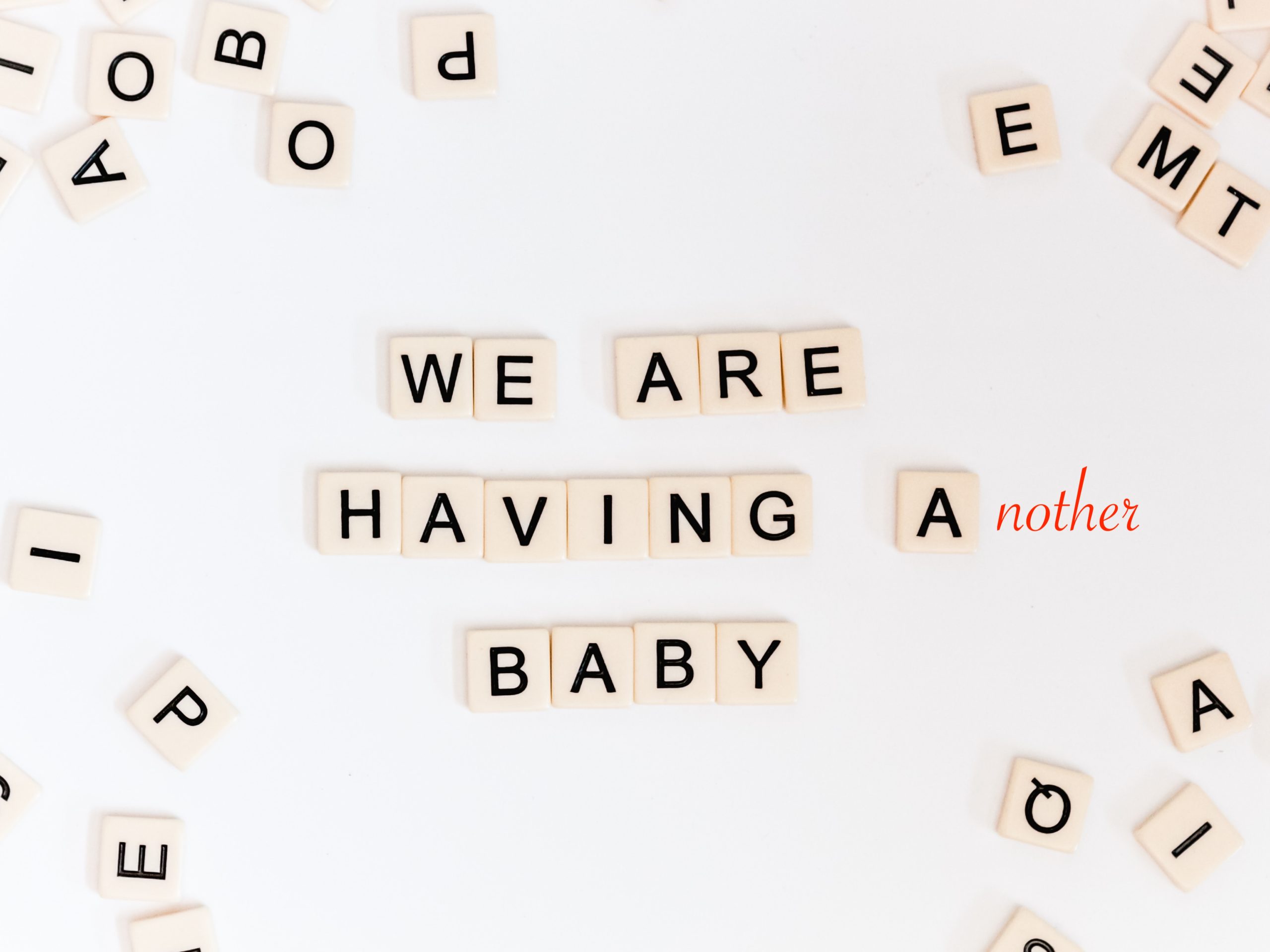 scrabble letters spell out, "We are having another baby"