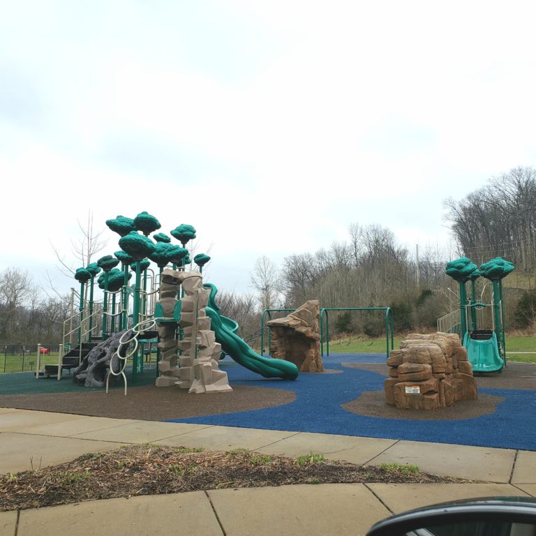 Playground with stone climbing structures and green plastic trees at Berry Park in Eureka
