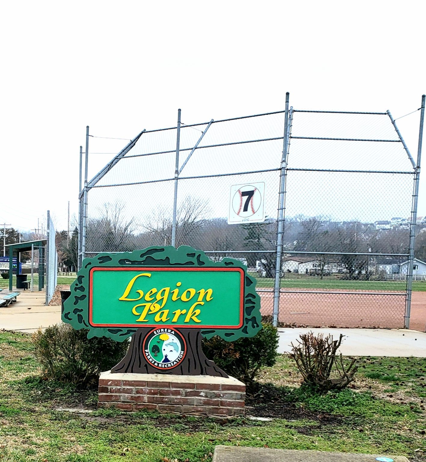 Baseball backstop behind a green Legion Park sign in Eureka