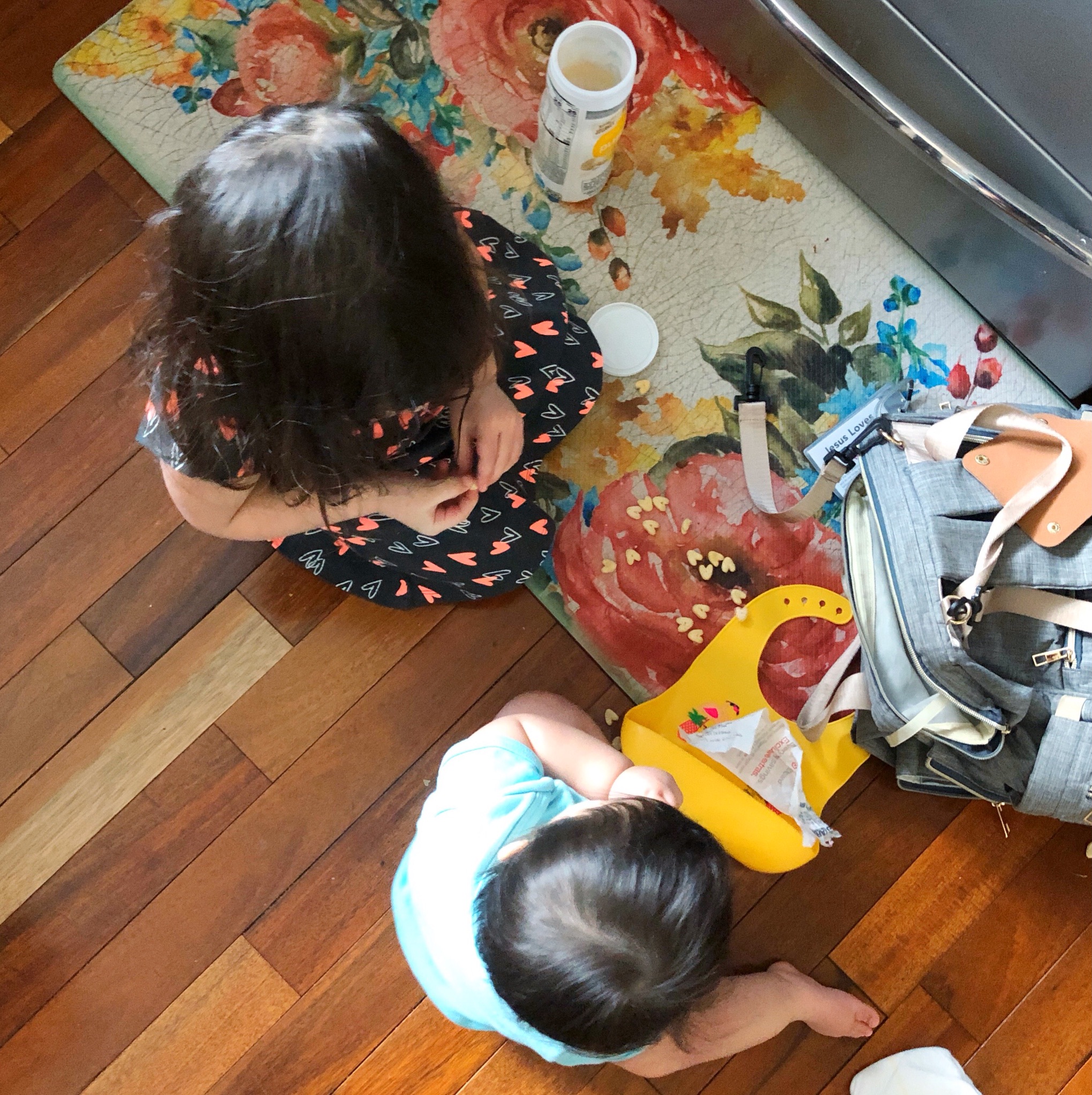 Going from one child to two, with a big sister and a little sister picnicking on the floor.