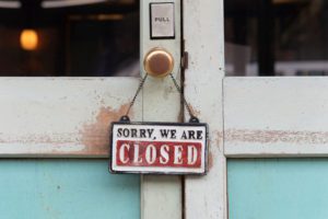Sorry We are Closed sign hanging on a restaurant door