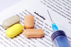 infertility literature with pills and a shot on top of it