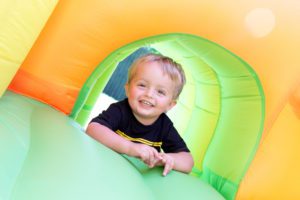 close up of a little boy playing on an inflatable bounce house