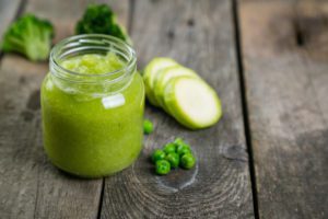 Green baby food purees in glass jars