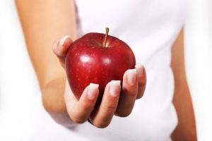 a close up of a woman holding an apple for a snack