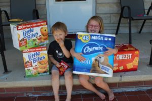 A mom learned pandemic lessons as she shows a photo of her two kids with bulk toilet paper and snacks.