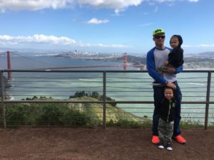 a single dad with his two sons on a hill in front of the Golden Gate Bridge