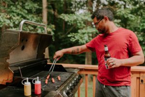 man grilling while drinking a beer on father's day