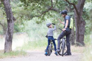 a father and son riding bikes on a trail