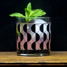 a cocktail glass with a sprig of mint coming out the top