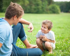 a father having a discussion with his son in the park