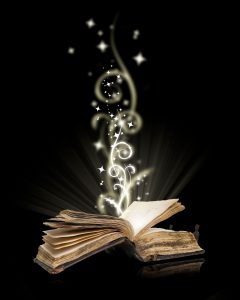 an open book on a black background with magical swirls and stars coming out of it