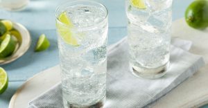 two glasses of sparkling water with lime wedges on a tabletop