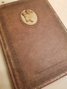 an old, brown, leather bound journal repurposed into a maternity journal