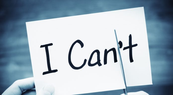 a black and white photo of the words, "I Can't" on an index card with two hands, cutting off the "t"