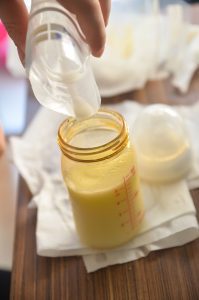 pouring breast milk from a pump into a bottle