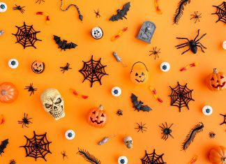 Halloween skulls, spider webs, and jack-lanterns scattered on an orange background