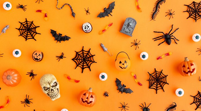Halloween skulls, spider webs, and jack-lanterns scattered on an orange background