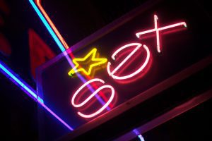 a neon sign with the word, "sex" in pink with a yellow star over it