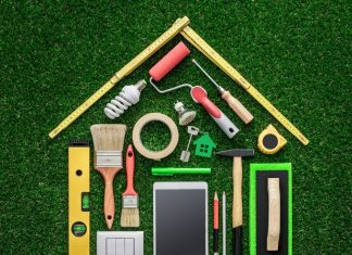 Tools laid out on green turf in the shape of a house to symbolize home renovations and DIY Projects