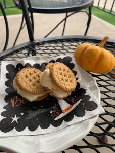a plate of cookies with ice cream stuffed inside on a white plate with a Halloween napkin to make a simple dessert