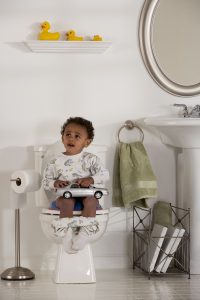 a toddler boy sitting on the toilet as he potty trains