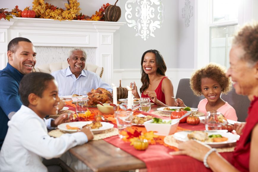 a Thanksgiving table with grandma and grandpa at the heads of the table, with mom and dad with their son and daughter