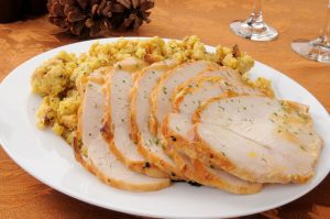 slices of turkey and dressing on a white dinner plate