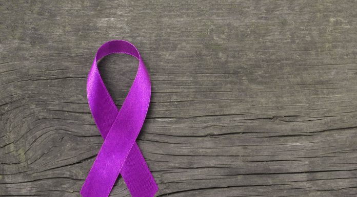 a purple ribbon on a wooden background to symbolize Alzheimers awareness
