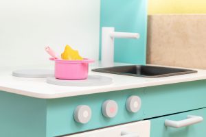 a close up of a mint green child's play kitchen