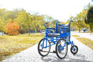 an empty wheelchair sitting on a park path