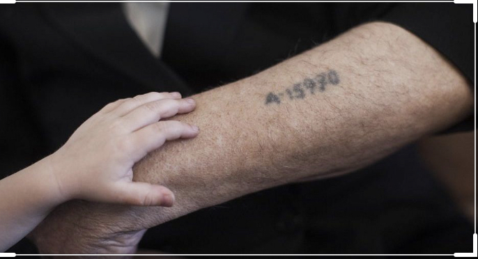 a close up of a holocaust tattoo on the arm of a survivor, with a child's hand resting on the arm