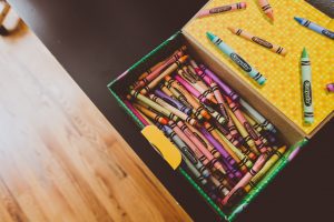 a box of crayons open on a tabletop ready to make crafts
