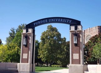 an archway on a college campus with a sign saying, "Purdue University"