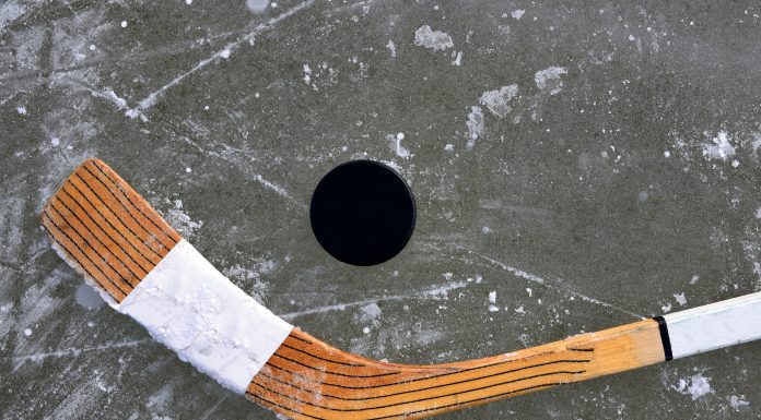 a hockey stick and puck on ice