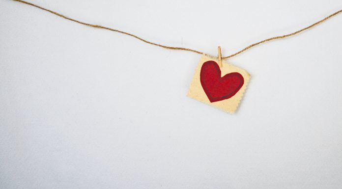 Valentine's Day heart painted on a piece of paper that is clotheslined to twine