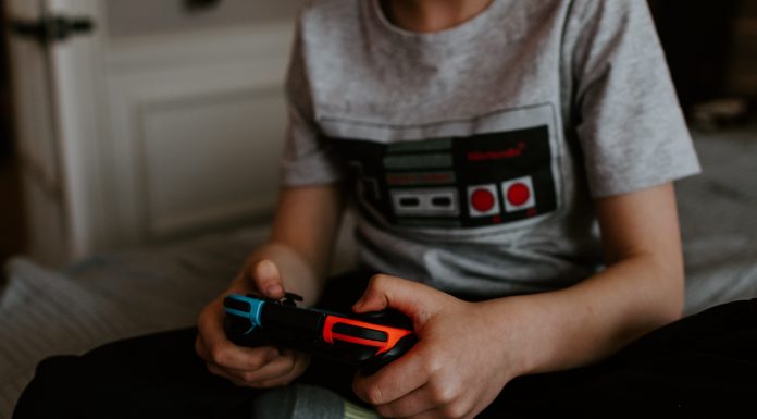 a person holding a Nintendo Switch controller in their hands