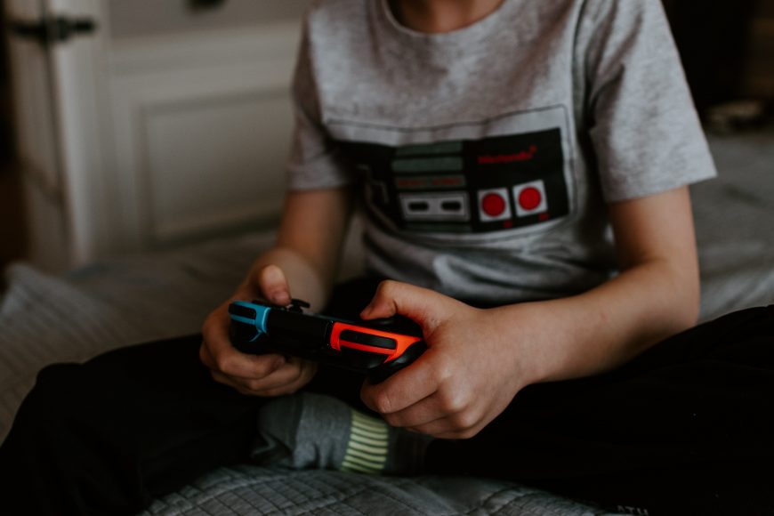 a person holding a Nintendo Switch controller in their hands