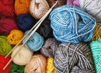 skeins of yarn in many colors along with a set of knitting needles