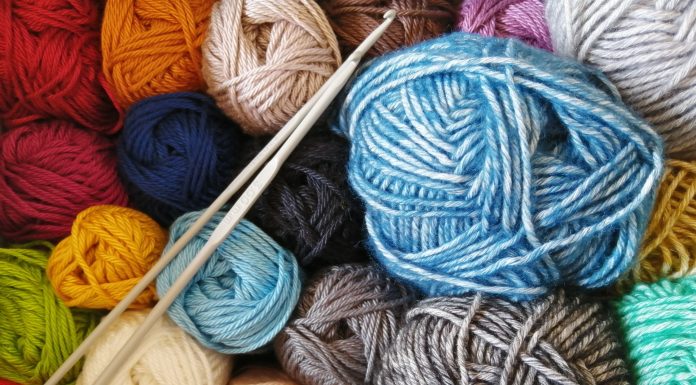 skeins of yarn in many colors along with a set of knitting needles