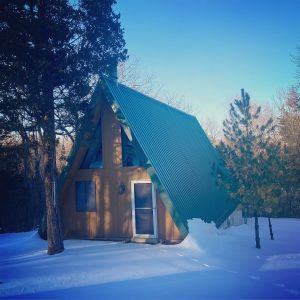 an A-frame cabin in the snowy woods