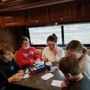 kids sitting around a table in an RV playing board games