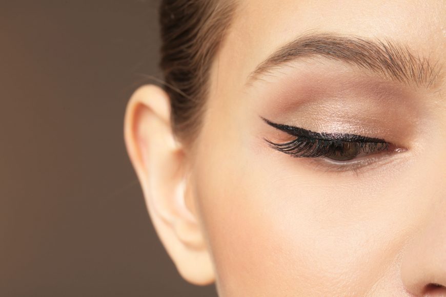 a close up of a woman with winged eyeliner make up