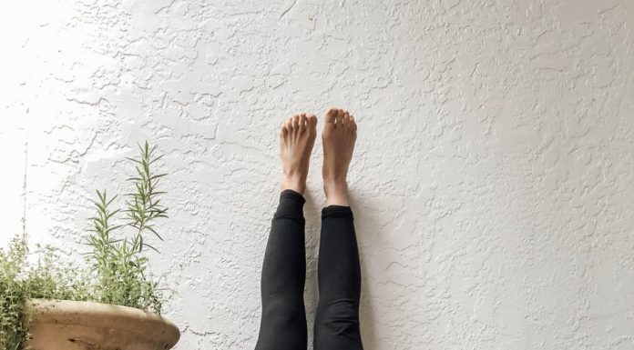a woman laying on the floor with her feet up against the wall to relax and handle stress