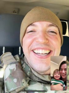 a video call with a man serving in the military smiling at his wife and son